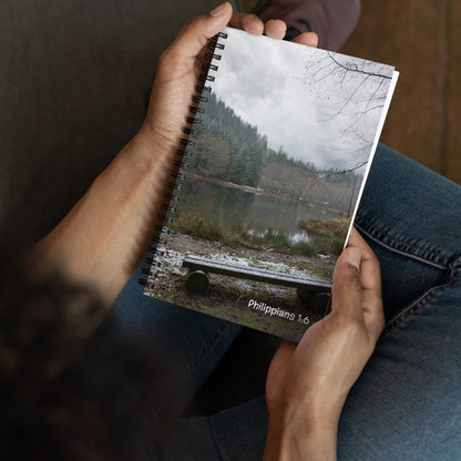 Person holding a notebook with a nature-themed cover
