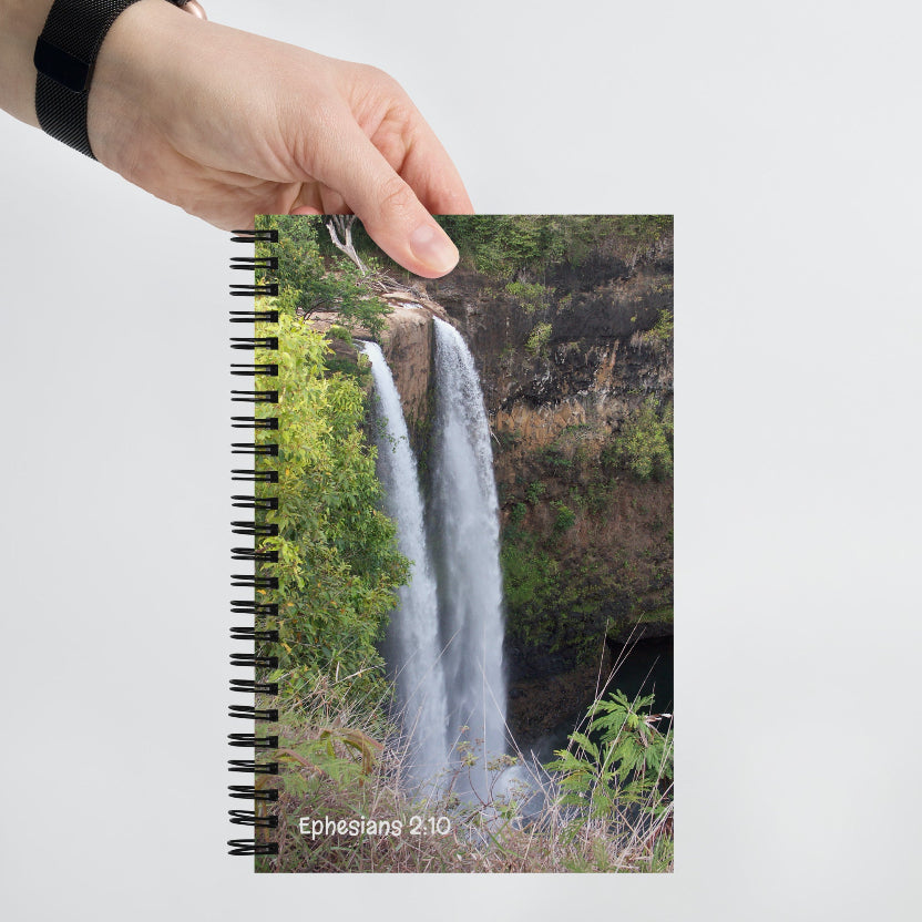 Notebook with a waterfall design on the cover held by a hand
