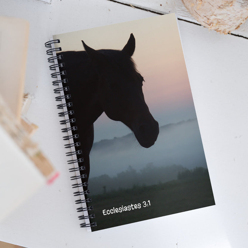 Notebook with a horse silhouette and text on a white surface