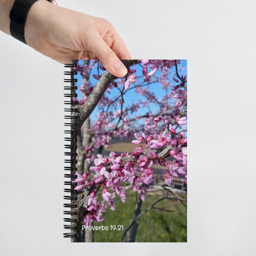 Notebook with a floral design on the cover held by a hand