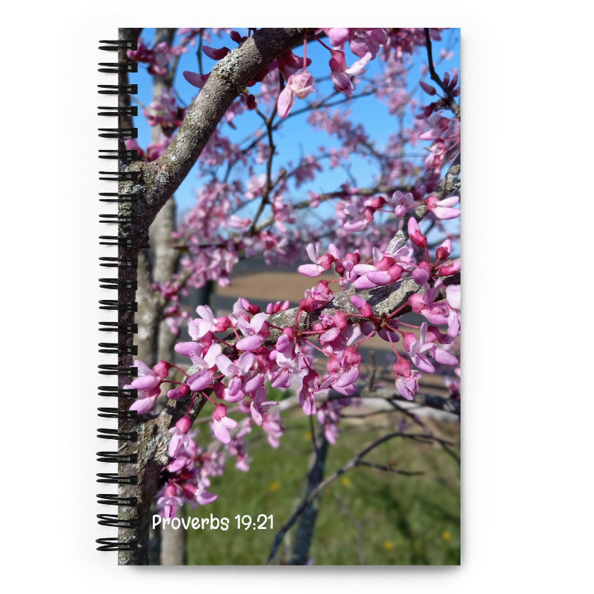 Notebook with a Kentucky pink flowering tree design and 'Proverbs 19:21' text on a white background