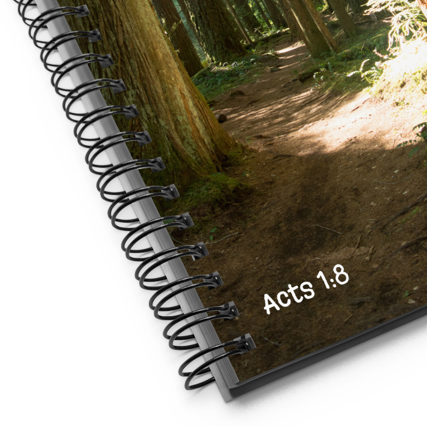 Notebook with 'Acts 1:8' text on a forest background