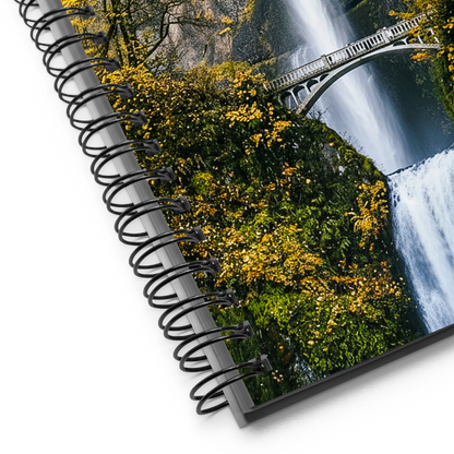 Spiral-bound notebook with a scenic cover featuring a waterfall and greenery