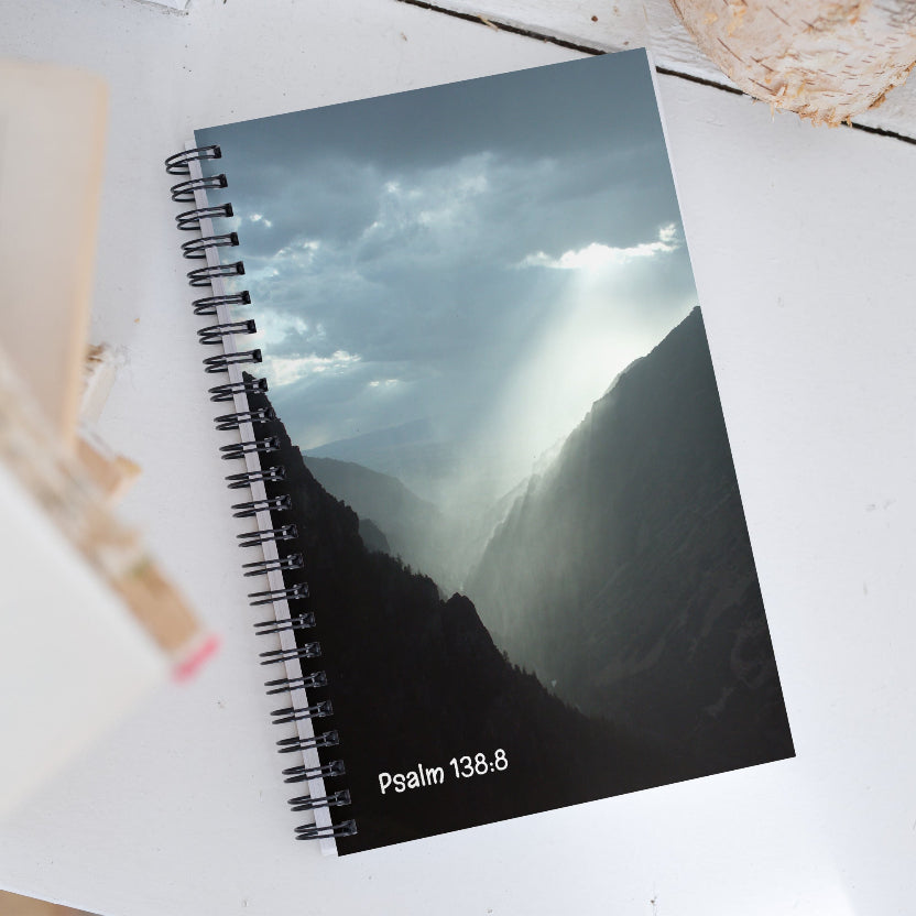 Notebook with mountain and sky design on cover, featuring Psalm 138:8 text.