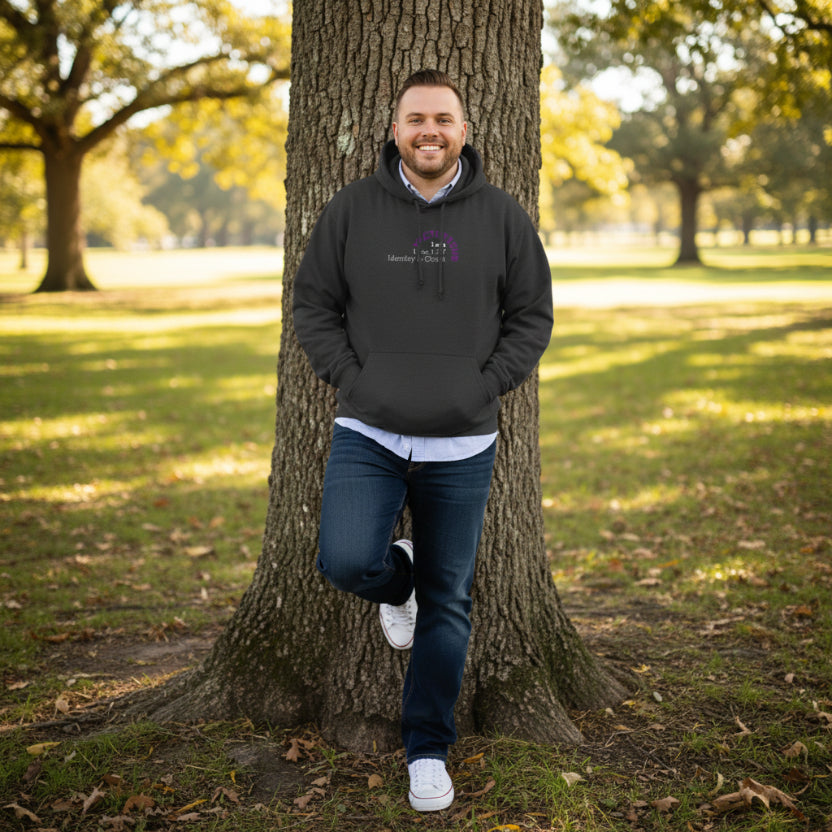 Charcoal black hoodie with 'I am Victorious, 1 Corinthians 15:57, Identity in Christ' leaning against tree at park