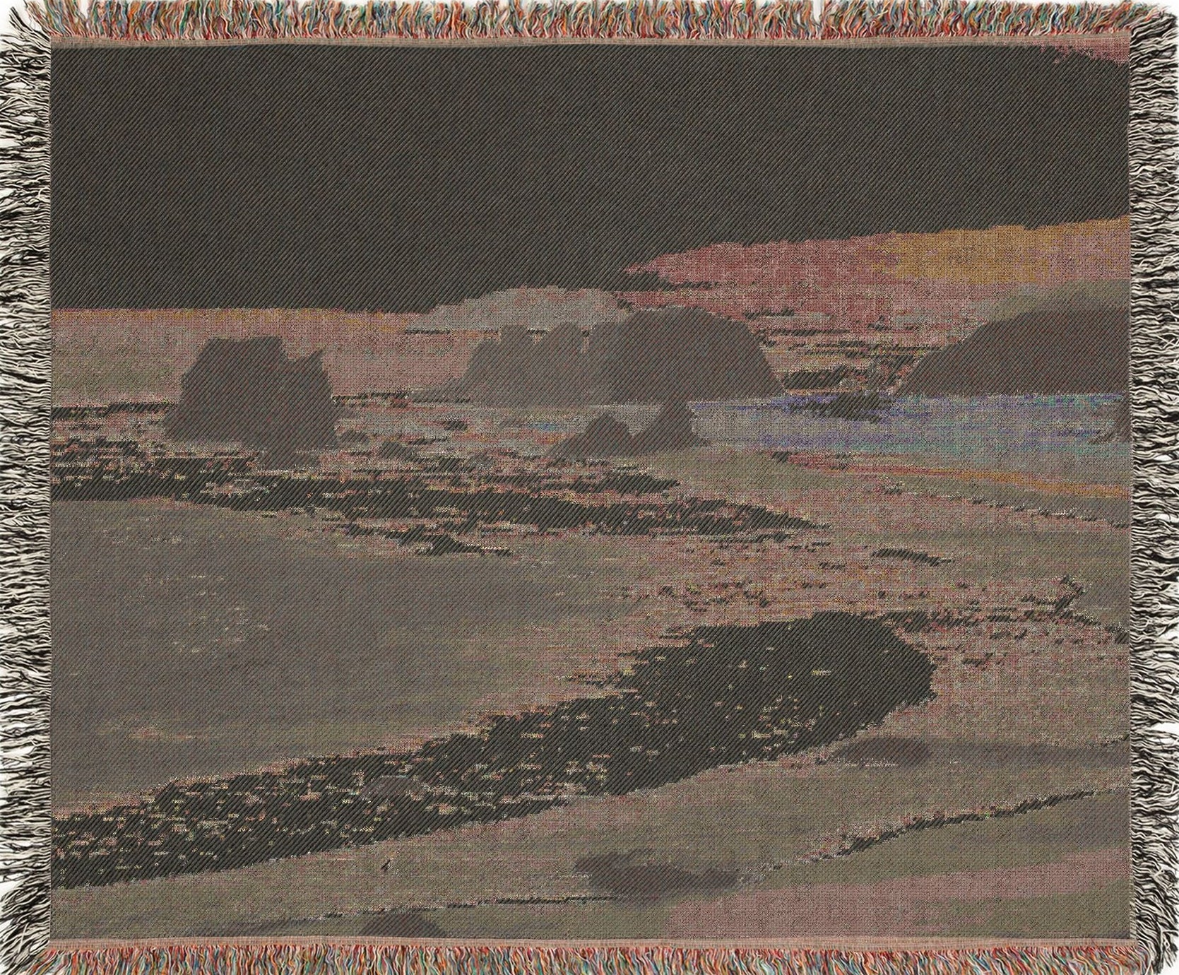 West Coast woven blanket with a landscape design of a beach and cliffs, backview.