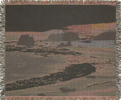 West Coast woven blanket with a landscape design of a beach and cliffs, backview.