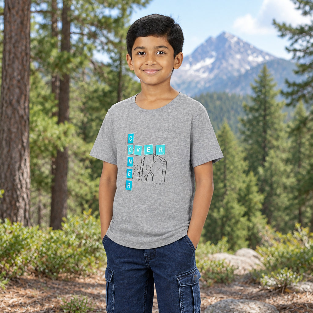 A young boy wearing a heather gray t-shirt with graphic print that reads 'overcomer', paired with dark blue jeans, photographed outside